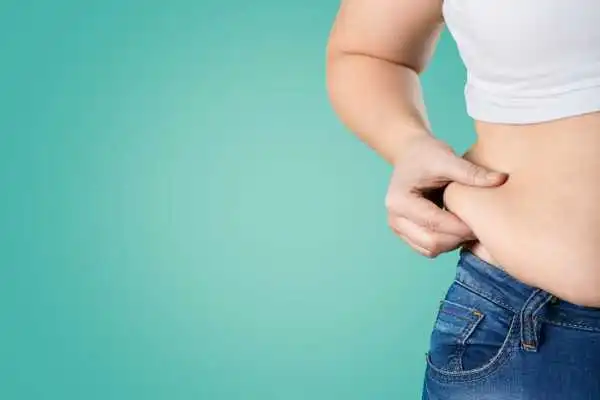 Image of woman pinching her love handles to show weight gain Glossop